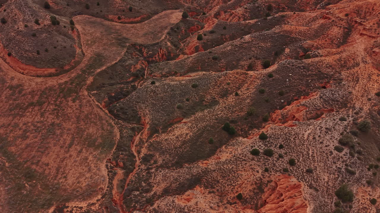 Paesaggio di canyon con colline aride e formazioni rocciose di giorno che mostrano diverse texture e colori del terreno