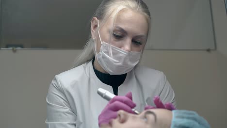 beauty salon cosmetologist in sterile gloves applies make-up