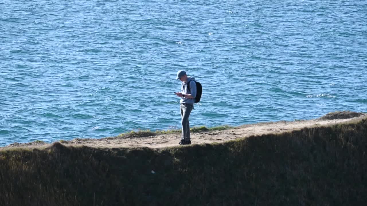 un hombre camina por la playa en el sur de inglaterra, dorset, camino de tierra