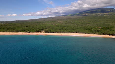 Calm-Pacific-Ocean-Makena-Beach-and-lushly-green-forest-on-Maui-Island,-Hawaii