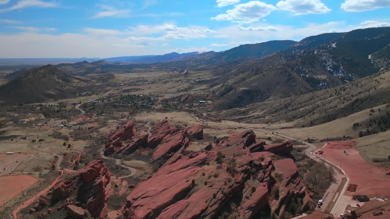 Red Rocks Park and Amphitheater Mount Morrison Colorado aerial drone large sandstone features mid winter windy roads walking trails Trading Post sunny blue sky clouds parking lot cars forward pan up