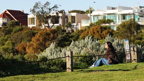 woman sitting near bushes at brighton beach