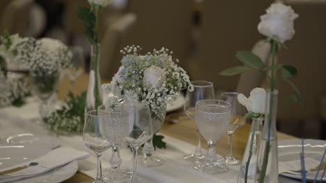elegant glassware and white floral arrangements on a refined wedding dinner table setup
