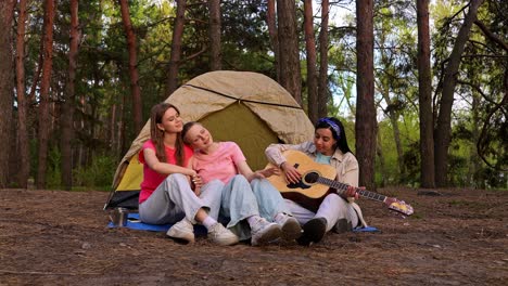 friends playing guitar in the forest