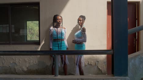 black models show off crochet projects in front of abandoned building