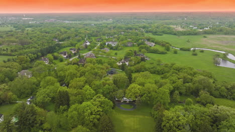 beautiful greenery with private mansions among. nature scenery of rural suburb against the backdrop of orange sky.