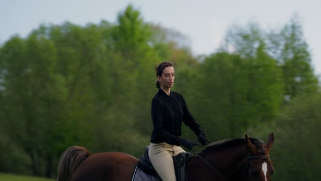 woman horseback riding in a field