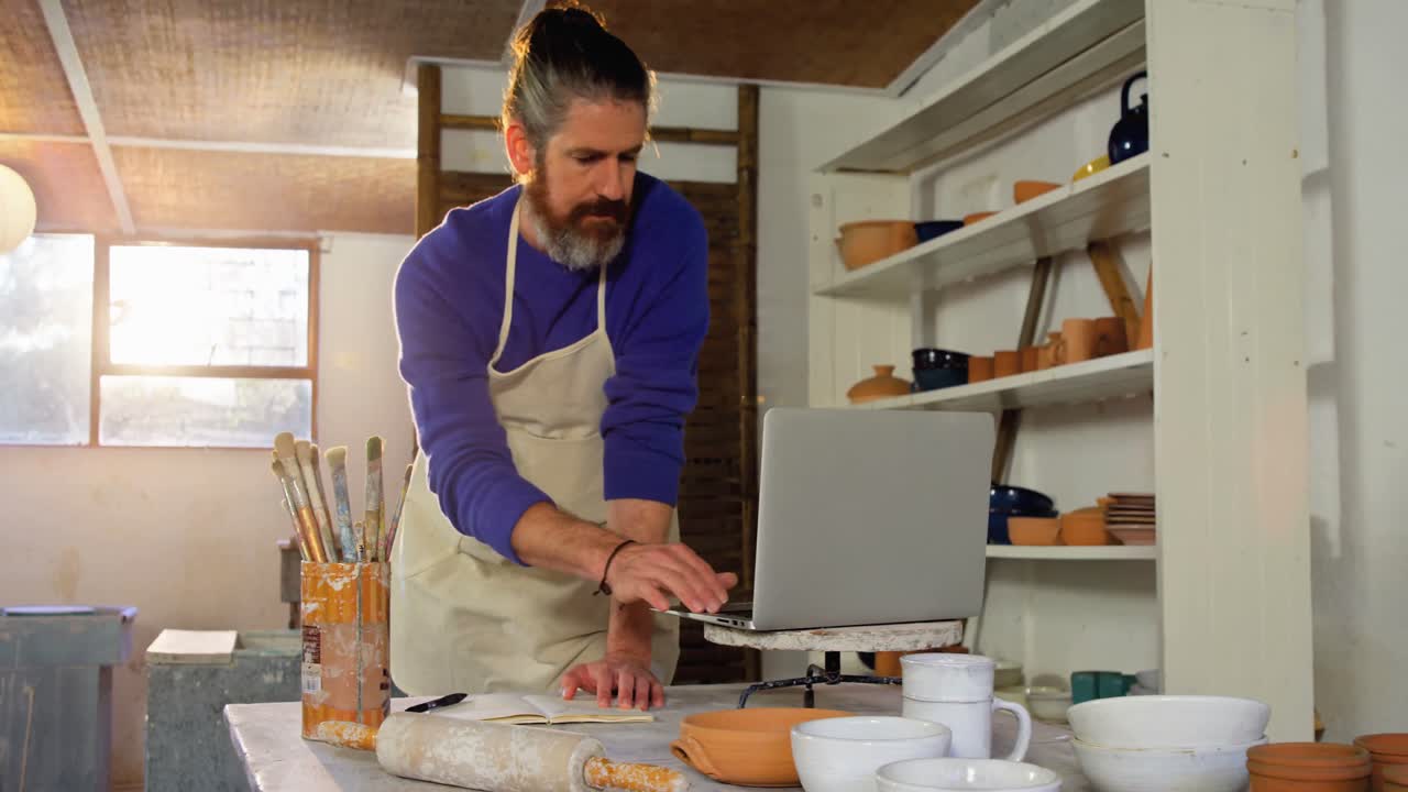 hombre alfarero escribiendo en un libro