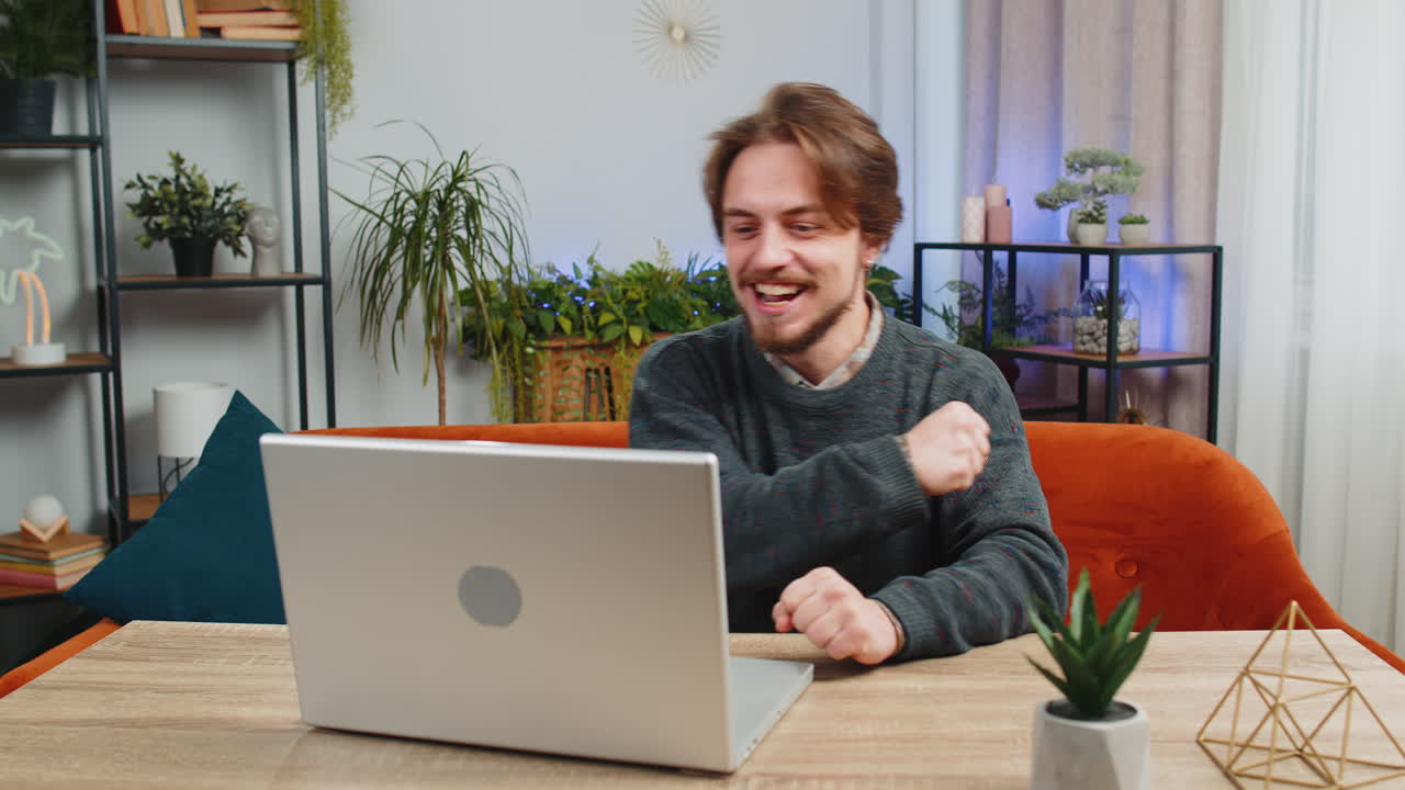 Amazed caucasian man use laptop computer receive good news message shocked by victory celebrate win