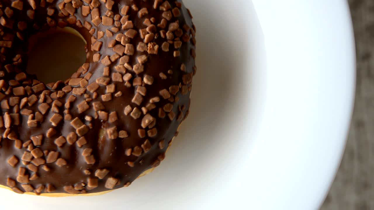 deliciosa rosquilla dulce con helado de chocolate girando en un plato. mesa de madera rústica. en bucle