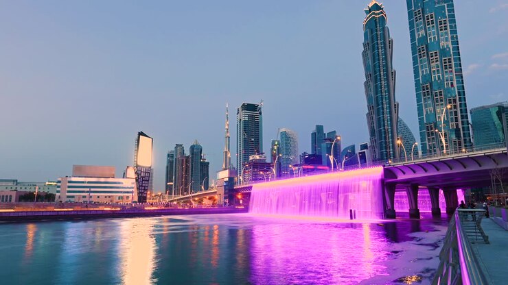 Superbe timelapse jour-nuit des magnifiques cascades roses sur le canal d'eau de Dubaï. Skyline de Dubaï illuminée en arrière-plan. Dubaï, Émirats arabes unis
