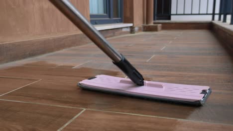 cleaning a patio floor with a mop