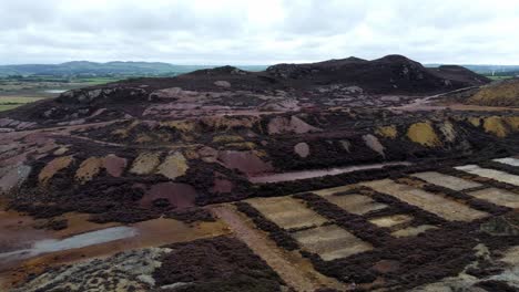 Parys-purple-mountain-abandoned-historic-copper-mine-red-stone-mining-industry-landscape-aerial-view-pan-right