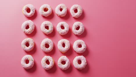 Video-of-donuts-with-icing-on-pink-background