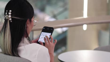 persona que utiliza el teléfono, posiblemente enviando mensajes de texto o navegando