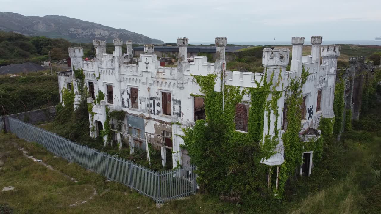 Aerial view orbiting Soldiers point house abandoned overgrown white castle secured mansion hotel