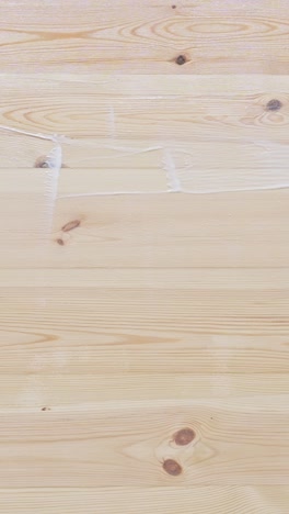 detailed vertical close-up of varnishing a hardwood floor during a diy home renovation