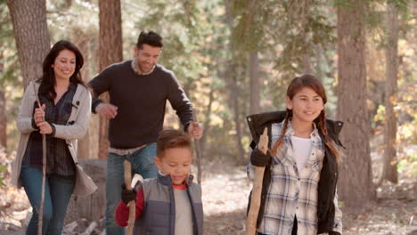 familia hispana caminando en el bosque caminando fuera del lado derecho del tiro