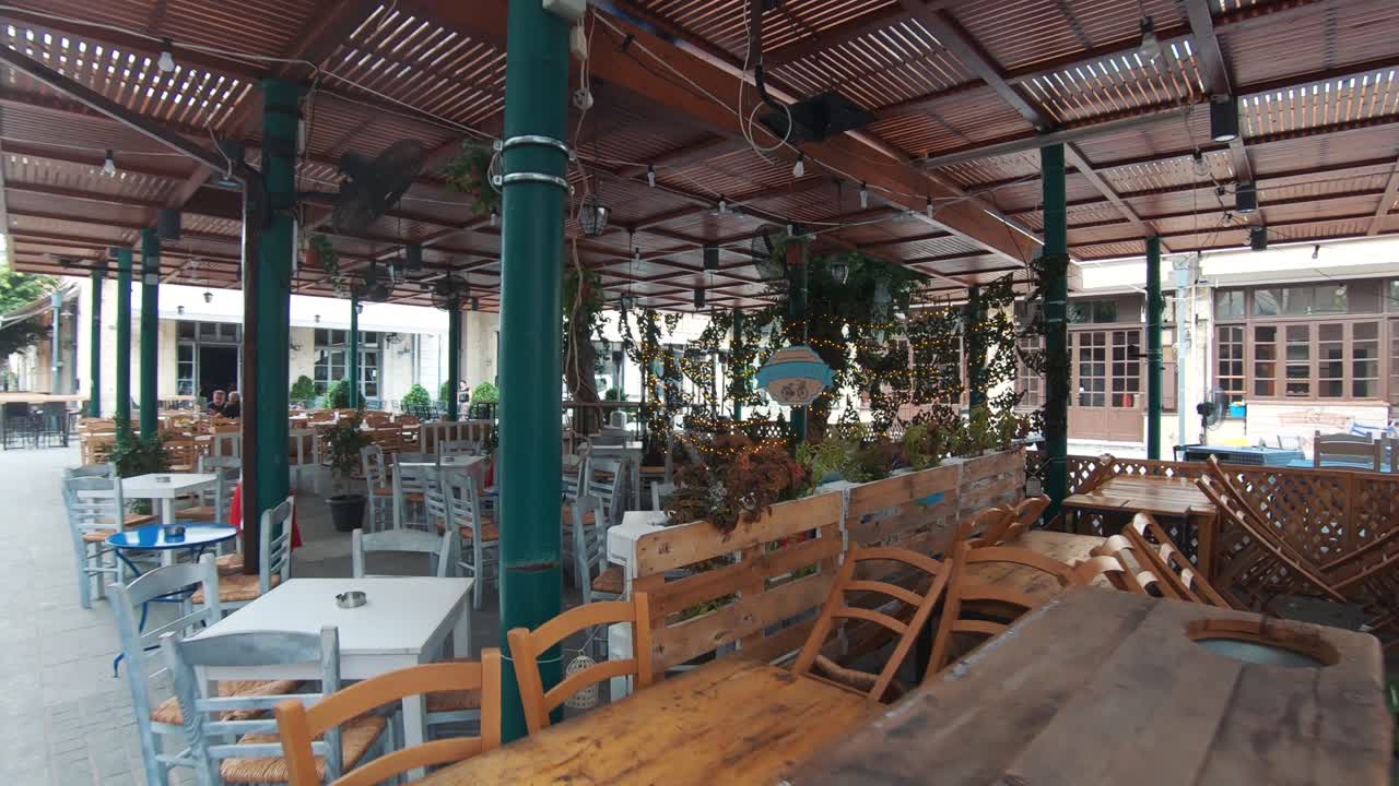 Restaurant Tables and benches in old town of Lemesos (Limassol) in Cyprus - Wide push in gimbal shot