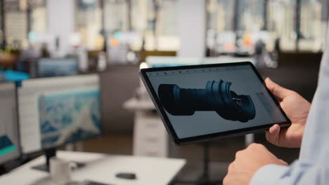 close up of researcher analyzing turbine on tablet to maximize sustainability