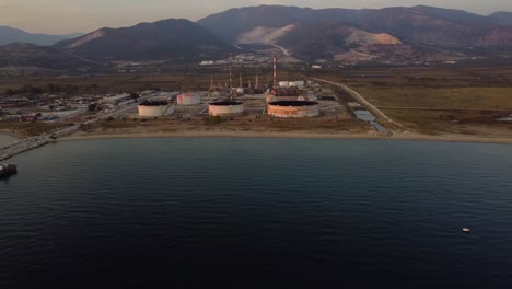 aerial pan of oil refinery from the sea