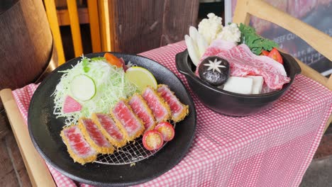 a collection of japanese food samples and dishes, including a whimsical hamburger sculpture and realistic replicas of gyukatsu and sukiyaki