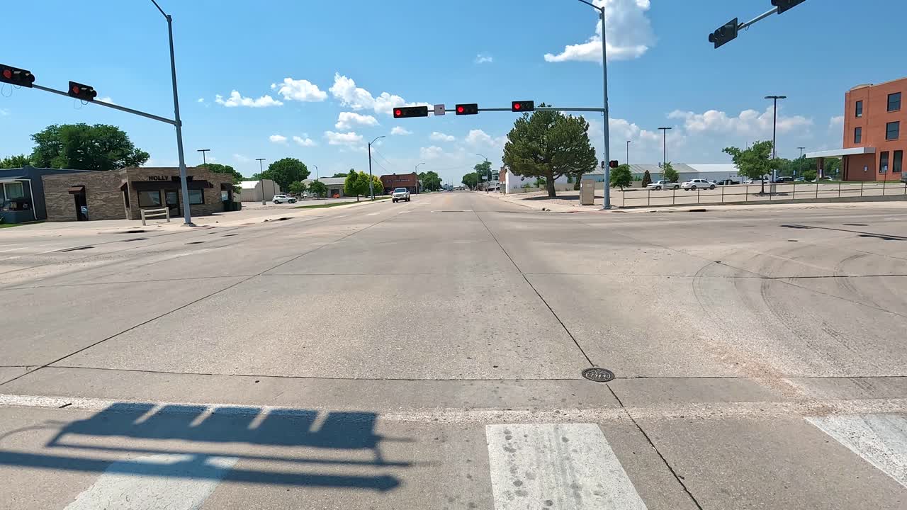 POV - Stopped at at red traffic light then driving through the business district of a small Midwestern town; concepts of small town living and my hometown