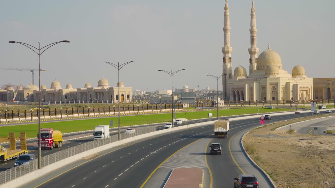 carretera de la ciudad con diferentes vehículos que viajan cerca de la mezquita de la universidad al qasimia en sharjah, emiratos árabes unidos