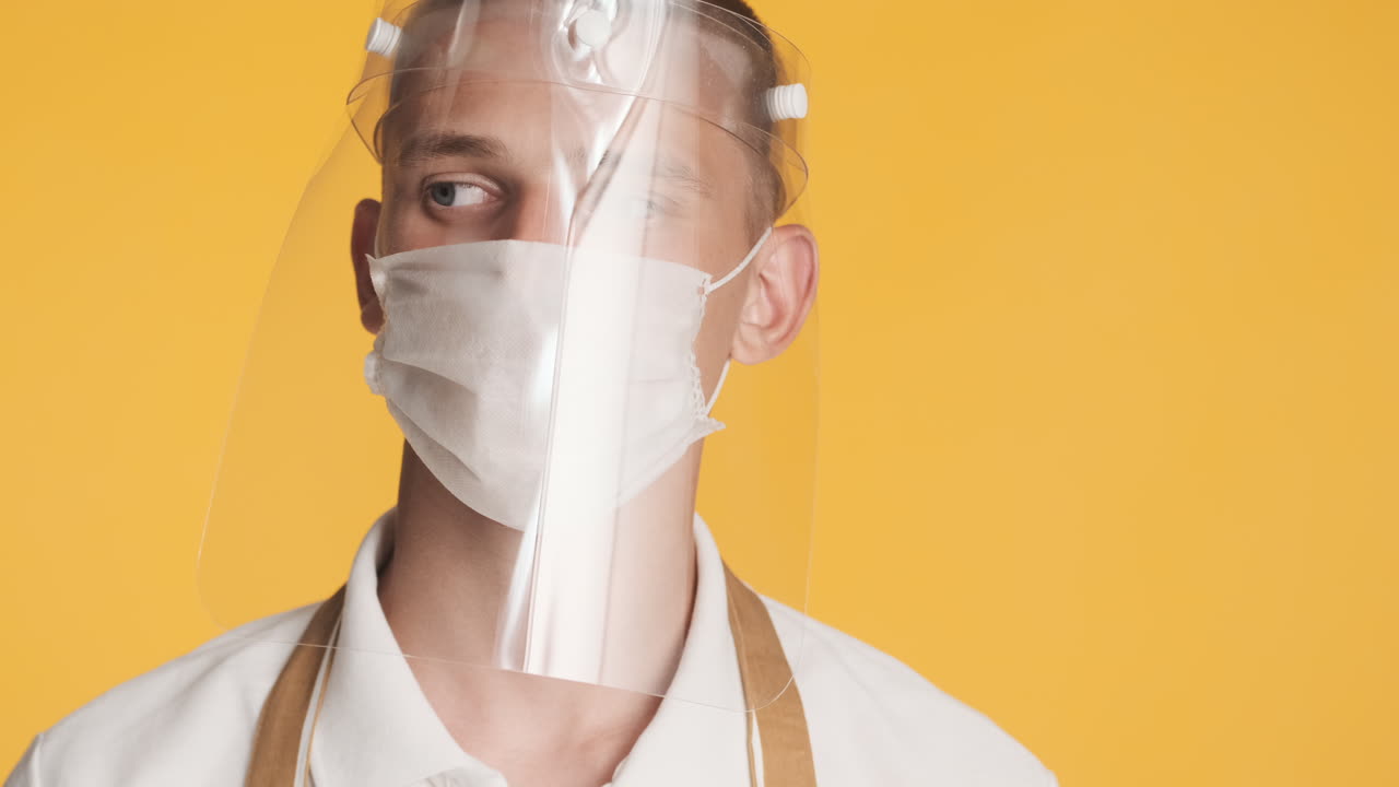 두 개의 얼굴 마스크를 쓰고 머리를 흔들고 있는 남자