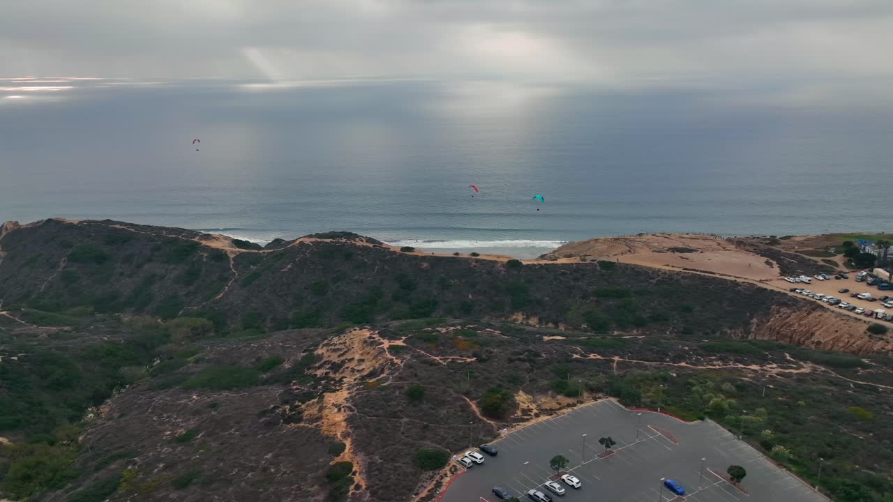 parapentes volando desde la plataforma de lanzamiento sobre la colina en la costa de la jolla, san diego, ca