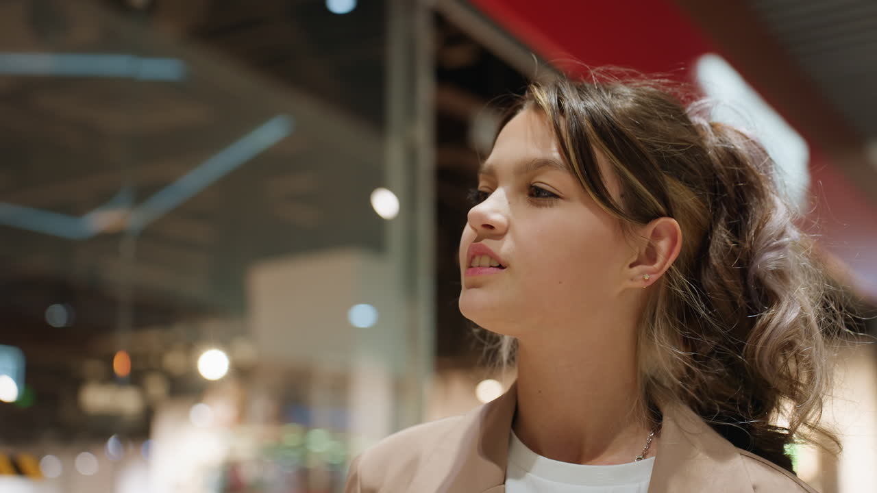 Niño pequeño observando su reflejo en el escaparate iluminado con adornos festivos; el niño examina con atención los reflejos en el escaparate en medio de la colorida iluminación festiva y decorativa.