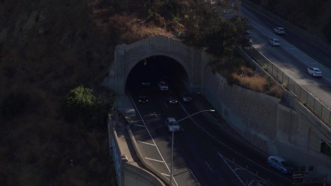 Ripresa con drone del traffico di Los Angeles che attraversa un ponte e esce da una galleria