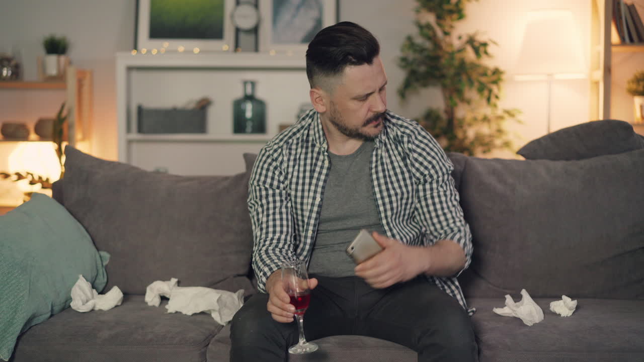 Man feeling unwell and sad while watching TV at home