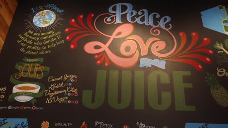 Establecimiento-De-Barra-De-Jugos,-Arte-En-La-Pared,-Paz,-Amor-Y-Jugo.