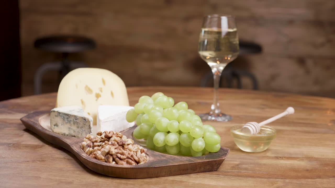 Cheese and Wine Charcuterie Board with Grapes, Walnuts, and Honey