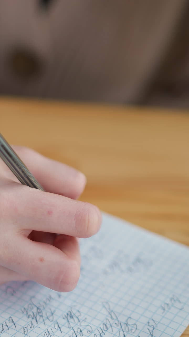 primer plano de la escritura de un estudiante en un diario en un paño tejido colocado sobre una mesa de madera, centrado en notas escritas a mano, demostrando hábitos de estudio y creatividad en un ambiente de espacio de trabajo acogedor