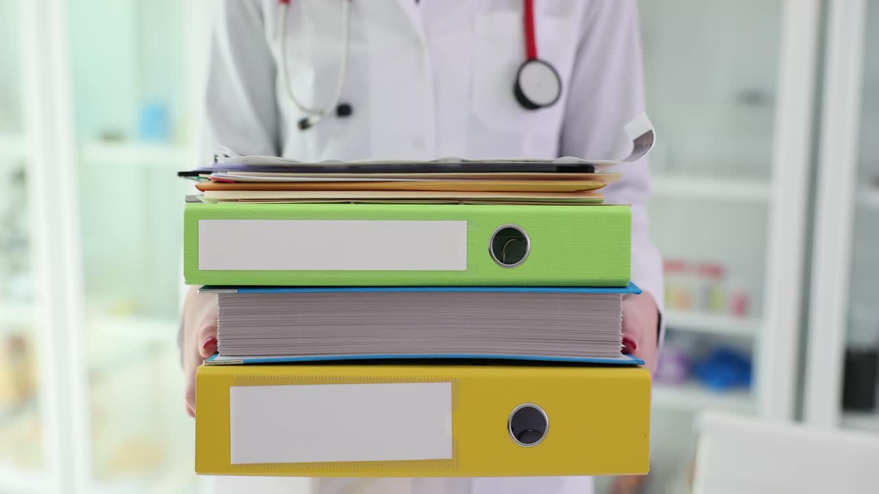 Doctor Holding Stack of Medical Files and Documents
