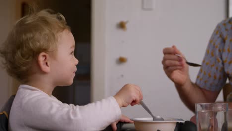 Caucasian-man-giving-food-to-baby-at-home