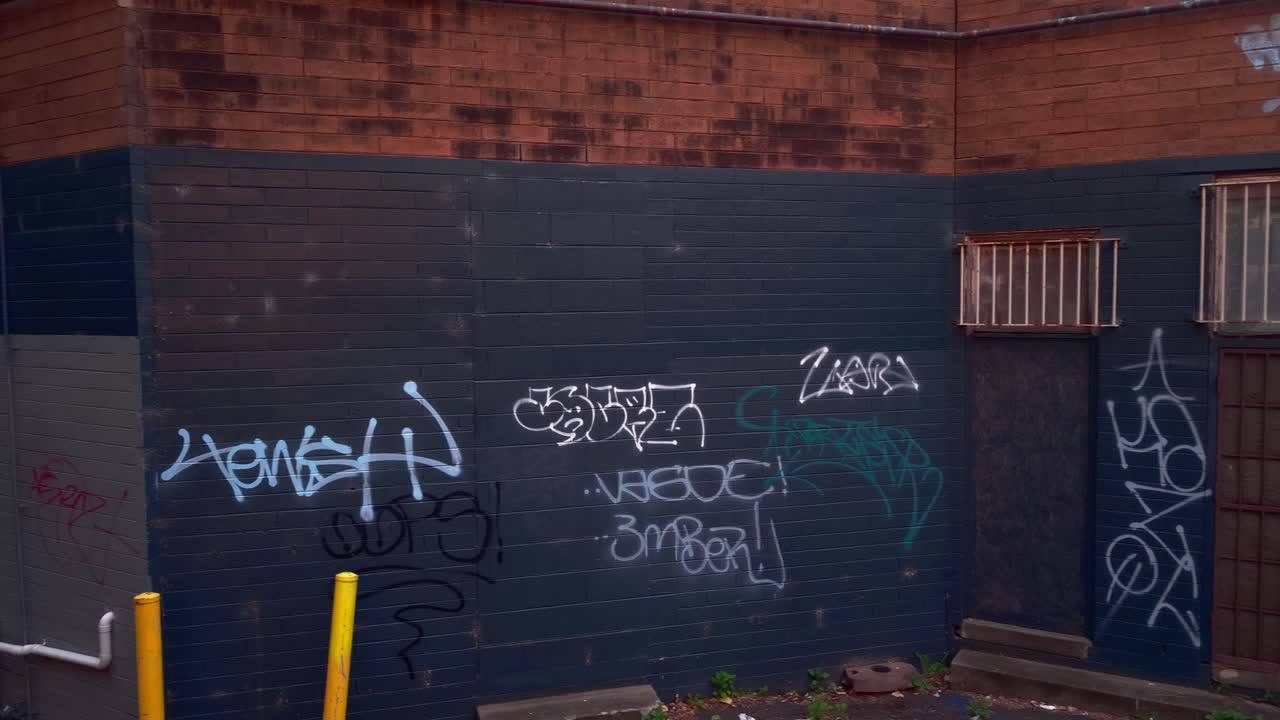Explore the vibrant graffiti art on brick walls in a Melbourne alleyway. Captured during golden hour, the dynamic colors and urban textures create a lively atmosphere
