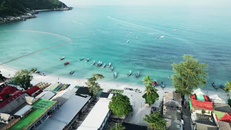 aerial view of haad rin beach, famous for its full moon party, showing the vibrant shoreline and turquoise waters of koh phangan