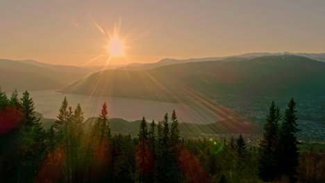 drone trucking shot of a setting sun over the aurlandsfjord with sunflaires in the lens