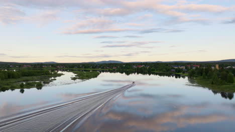 perfect reflections through calm lake with sailboat during