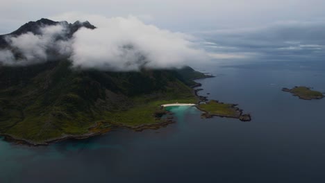 scenic lofoten islands, norway. cloudy green mountains and cliffs above sea and dreamy sandy beach. aerial