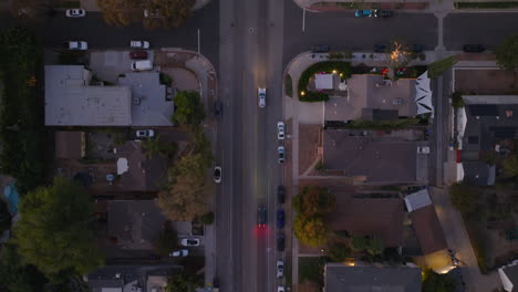 drone shot of cars driving slowly down street as sun goes down, twilight traffic