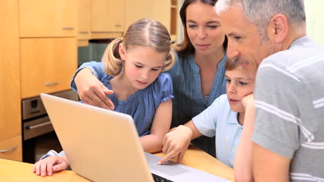 familia sonriente usando una computadora portátil