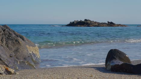 rocks, sand, pebbles and the ocean waves