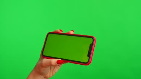 woman holding a smartphone with green screen