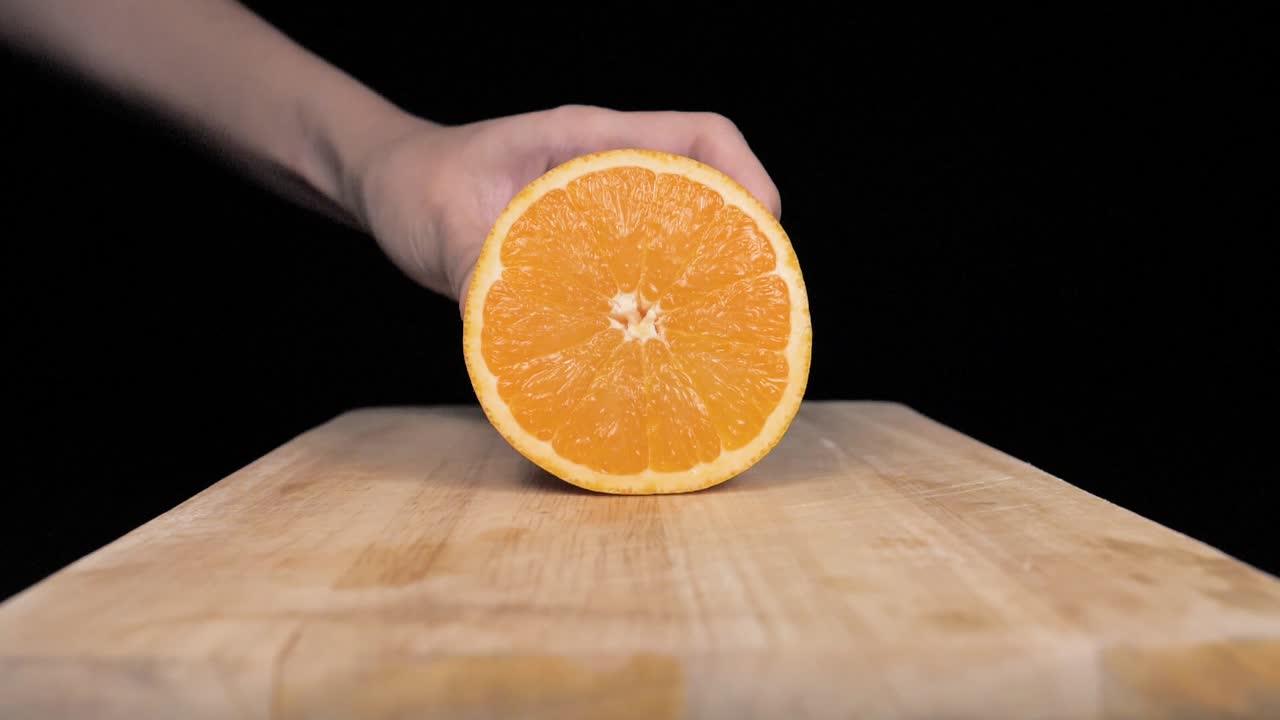 una fruta naranja se pone en una tabla y se corta en rodajas a cámara lenta, uhd