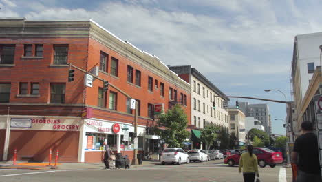 wide angle of people and cars moving through downtown portland, oregon, usa on a sunny day.