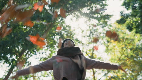 mujer, otoño y tirando hojas al aire libre